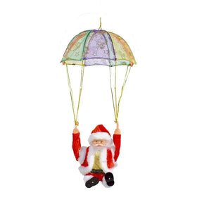 Red and white santa claus figurine with a rainbow-colored parachute above him.