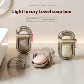 Transparent and metallic travel soap box with a sleek, modern design featuring red zipper pulls.