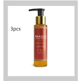 A sleek amber glass bottle with a gold pump and black cap, labeled ’magic luxury body oil’ in elegant white lettering.