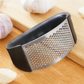 Silver garlic press with black rubberized handles and a perforated metal grating surface.