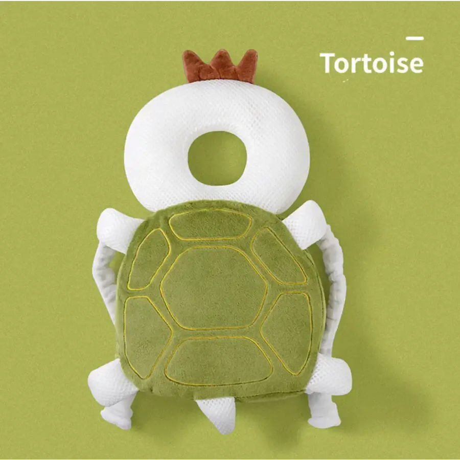 A plush tortoise-shaped baby head support with a white mesh body, green felt shell outlined in yellow stitching, and brown fabric crown.