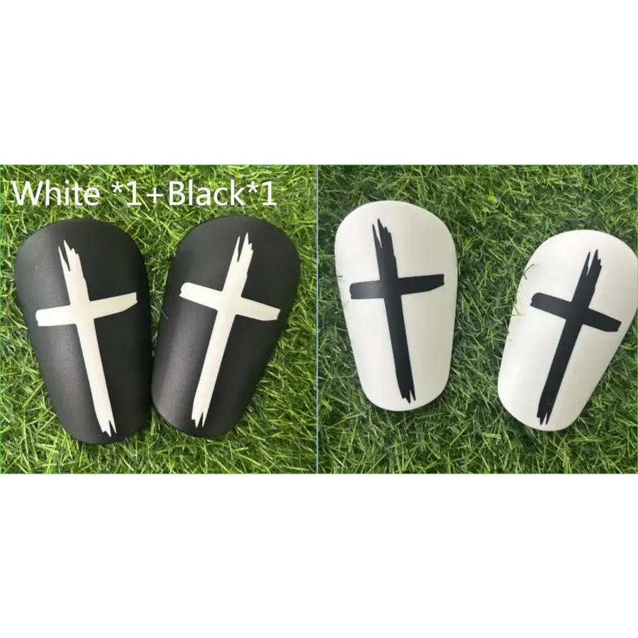 Black and white soccer shin guards with bold cross decals