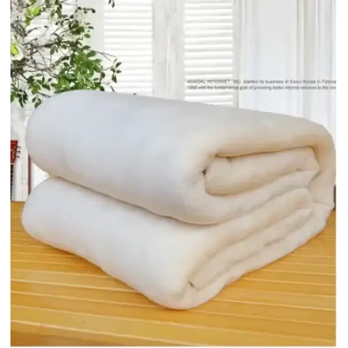 A plush, off-white fleece blanket neatly folded into a compact stack.
