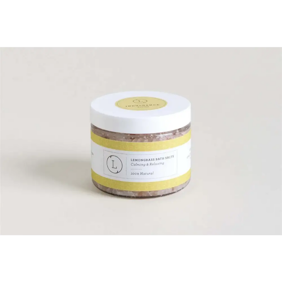 A white cylindrical jar with a yellow label and lid, containing lemongrass bath salts.