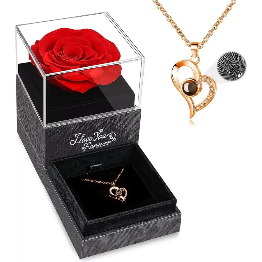 A rose gold heart-shaped pendant necklace with a dark brown gemstone and sparkling rhinestones, displayed in an elegant black gift box alongside a preserved red rose.