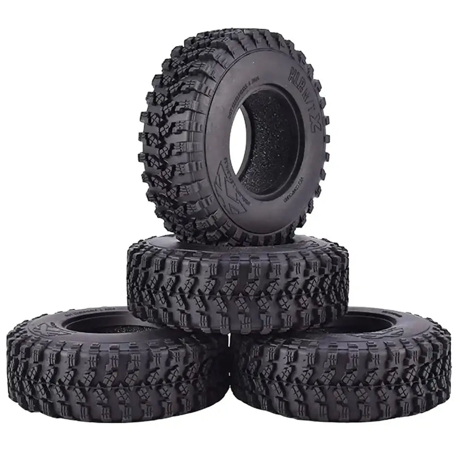 Black rubber off-road tires with aggressive tread patterns, designed for rugged terrain.