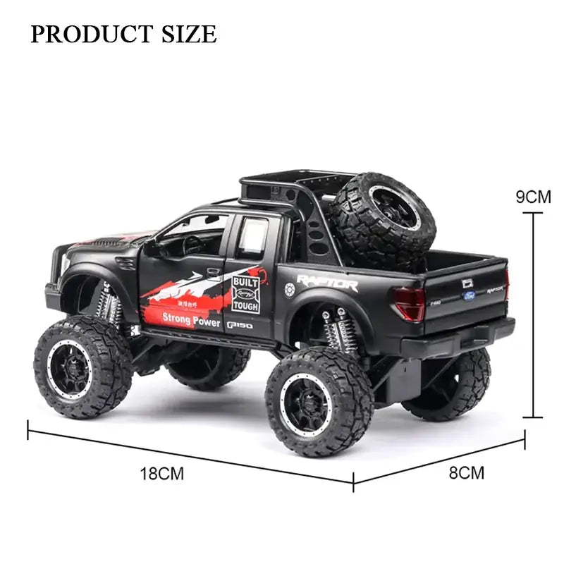 Black die-cast ford raptor pickup truck model with red and white decals, oversized tires, and a spare tire mounted on the bed.
