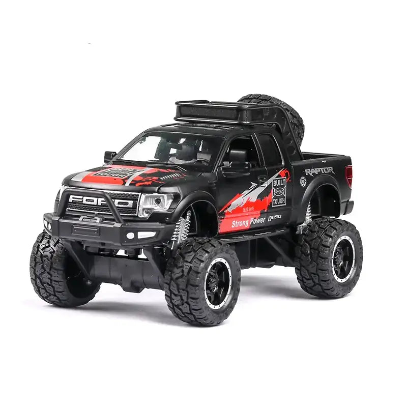 Black die-cast ford raptor truck model with red and silver graphics, oversized off-road tires, and a roof-mounted spare tire.
