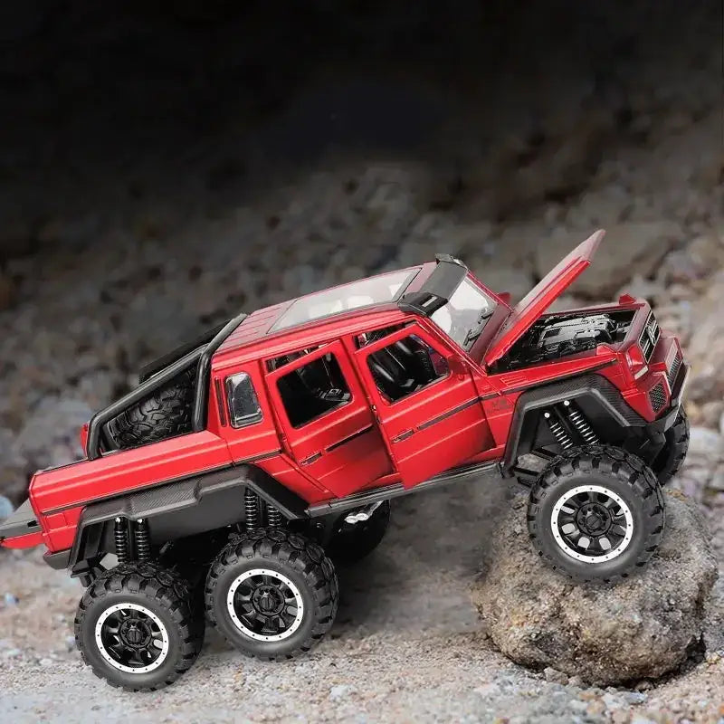 Red die-cast six-wheel-drive off-road truck model with black tires and detailed suspension.