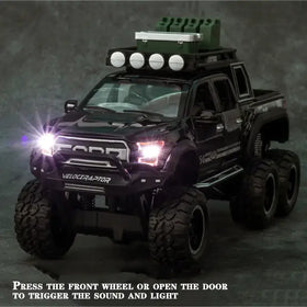 Black die-cast toy pickup truck with oversized tires, roof-mounted lights and a green cooler.