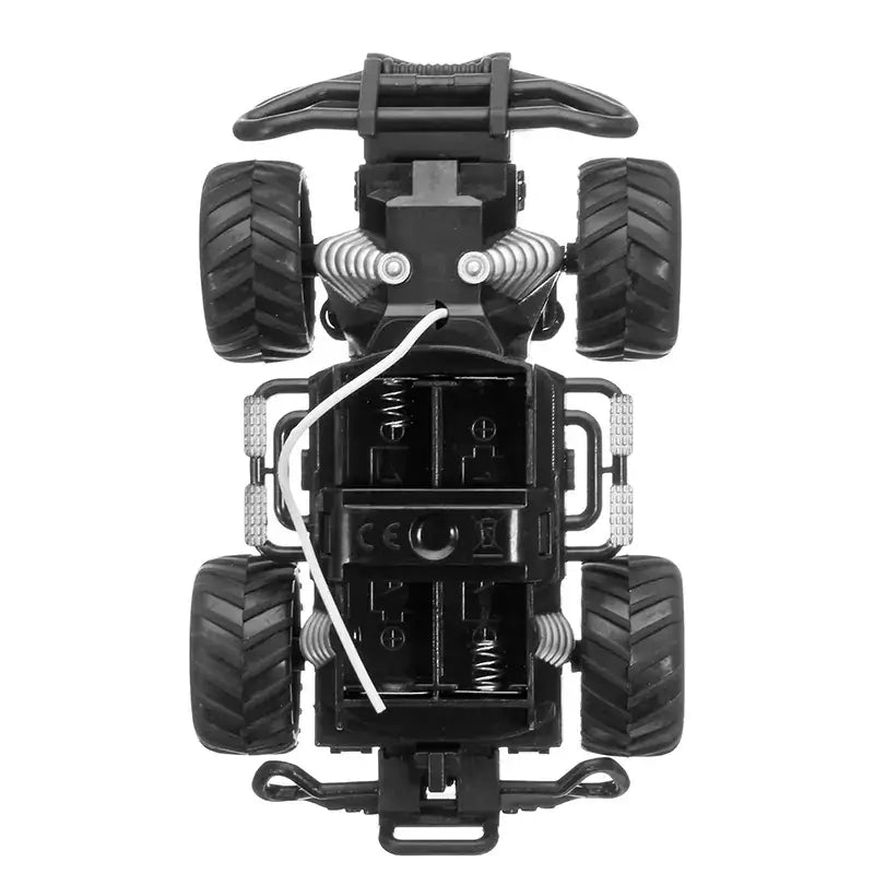 Black plastic remote-controlled monster truck with rugged tires and silver coil springs.