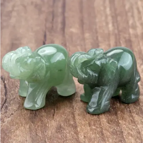 Two intricately carved green jade elephant figurines, one lighter and one darker in hue.