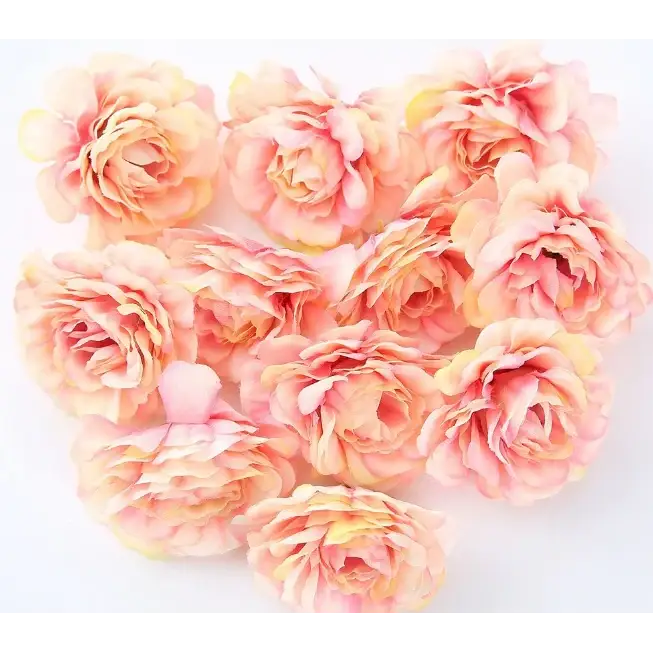 A cluster of delicate, peach and soft yellow artificial peonies with layered petals.