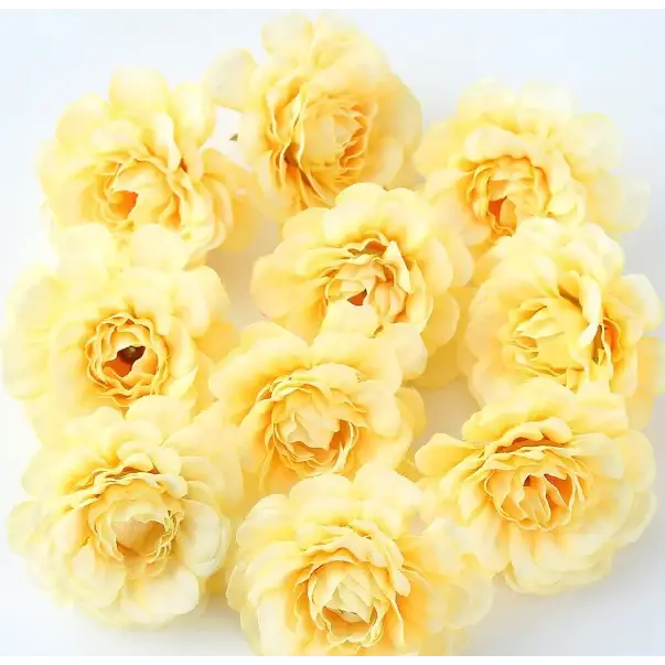 Soft yellow artificial roses with delicate, layered petals and a slightly textured surface.