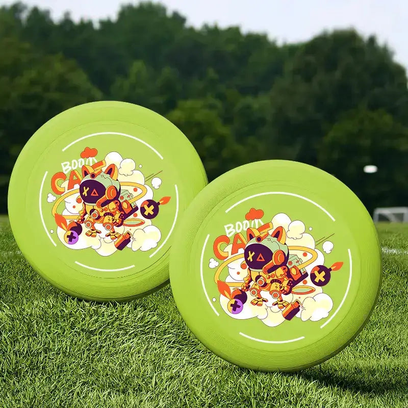 Two bright lime green flying discs featuring a colorful cartoon robot design with the text ’boom candy’ and playful graphics.