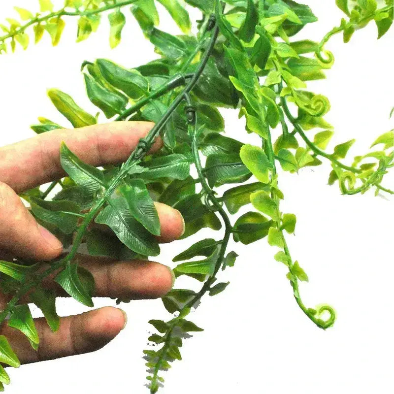 Green artificial fern vine with detailed, glossy leaves and slender stems.