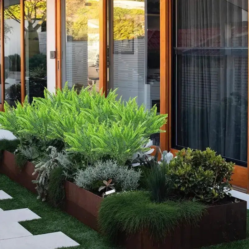 Rectangular planter box filled with lush green ferns and silvery foliage, crafted from weathered rust-colored metal.