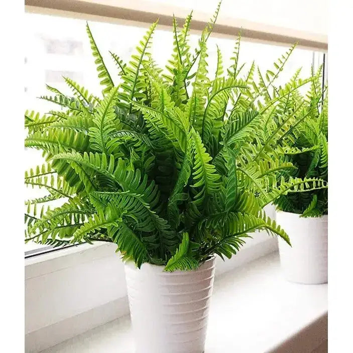 Lush green artificial fern plant in a white ribbed pot.