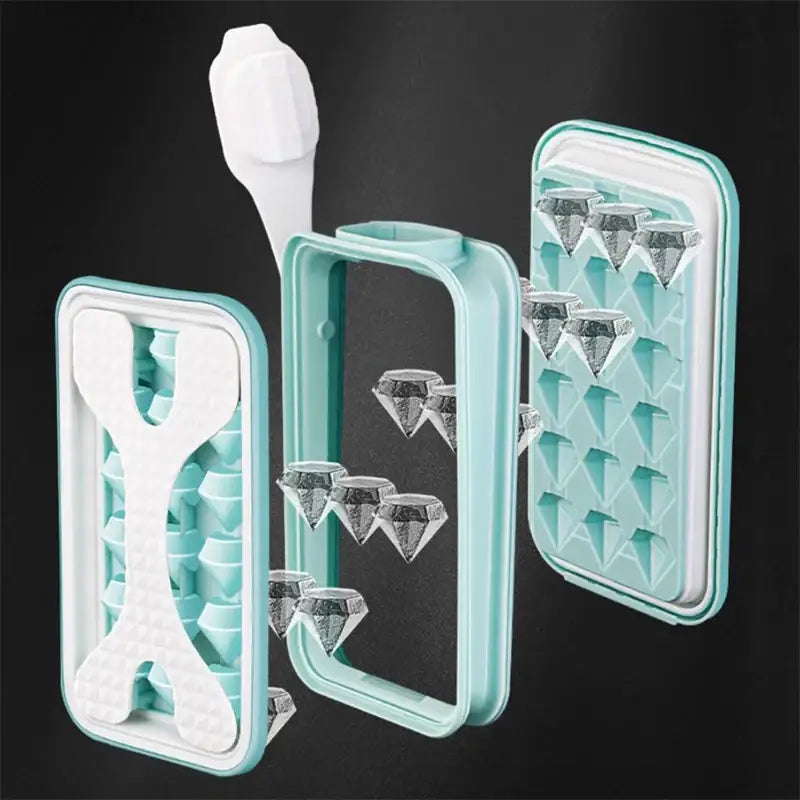 Set of three turquoise silicone ice cube trays with diamond-shaped molds and a white plastic scraper tool.