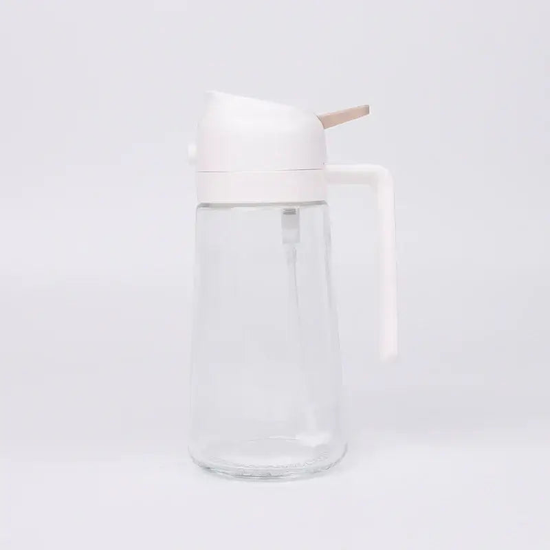 Clear glass oil dispenser with a white plastic lid and handle, featuring a wooden spout for controlled pouring.