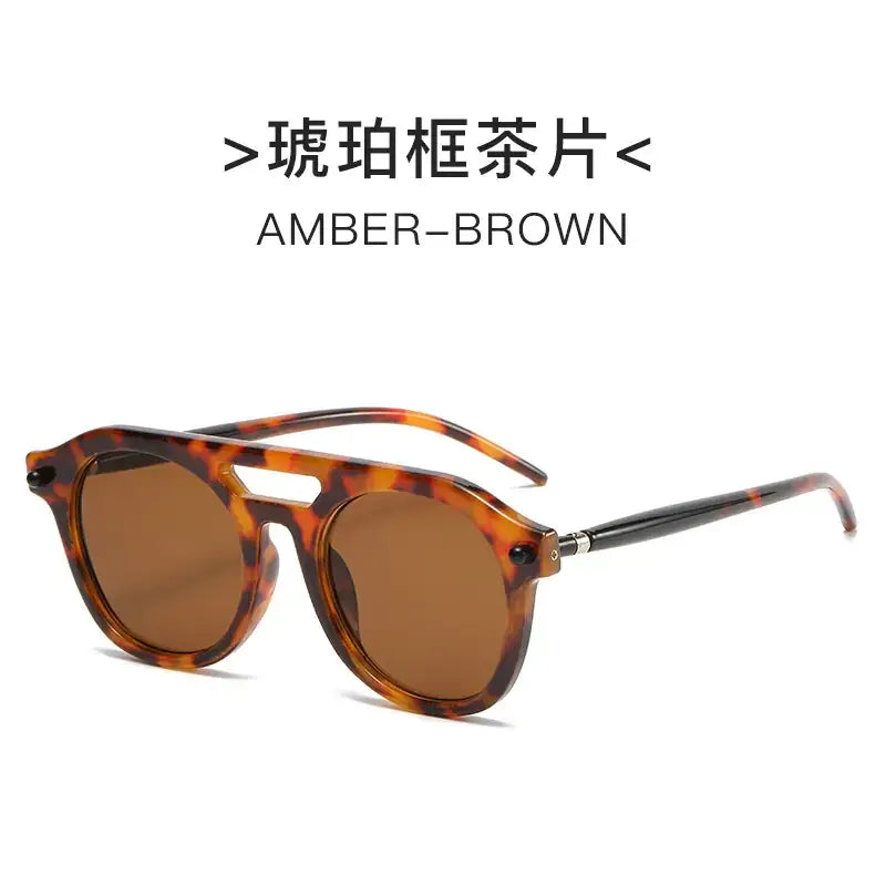 Amber-brown tortoiseshell-framed sunglasses with a vintage aviator design and dark amber lenses.