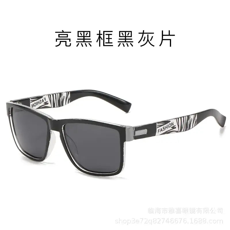 Black-framed sunglasses with dark gray lenses and zebra-striped temple arms featuring the word ’fashion.’
