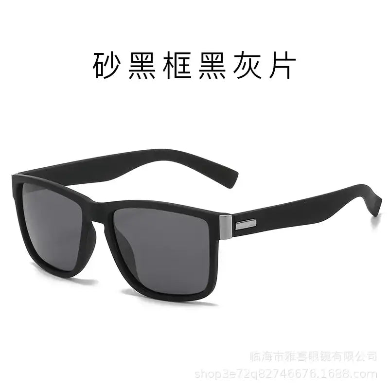 Sunglasses with a matte black frame and dark gray lenses, featuring a sleek rectangular design accented by silver metal detailing on the temples.