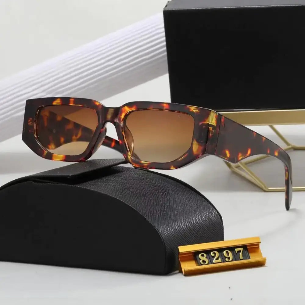 Tortoiseshell-patterned rectangular sunglasses with gradient brown lenses, displayed on a black textured case.