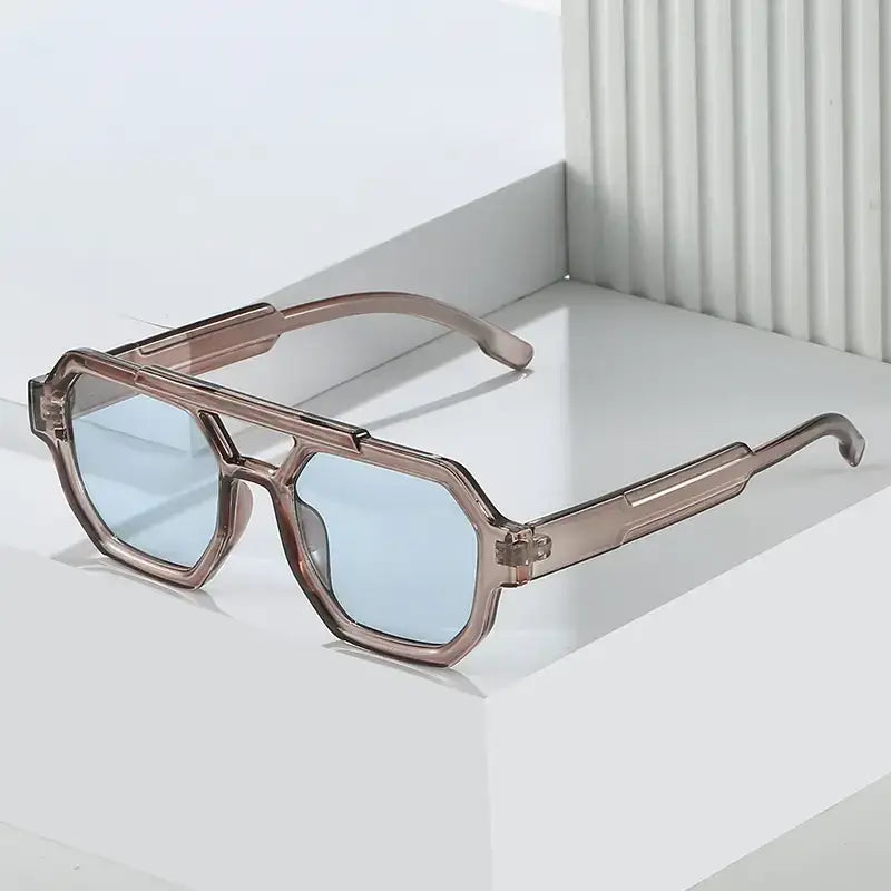 Brown-tinted, geometric-framed sunglasses with light blue lenses and a sleek, modern design.