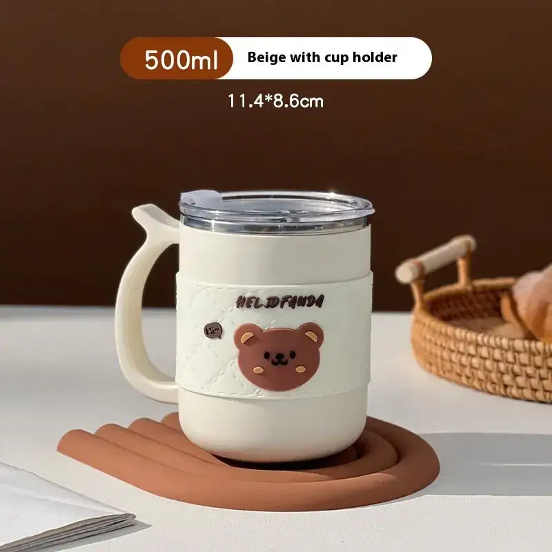 Beige 500ml insulated mug with a clear lid, integrated cup holder handle, and a cute brown bear face decal on its side.
