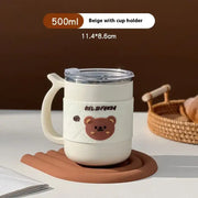 Beige 500ml insulated mug with a clear lid, integrated cup holder handle, and a cute brown bear face decal on its side.