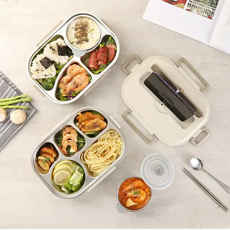 Stainless steel bento box with a beige lid and multiple compartments filled with various meals.