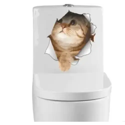 A cute tabby cat peeking through a torn paper effect decal on a white toilet tank.