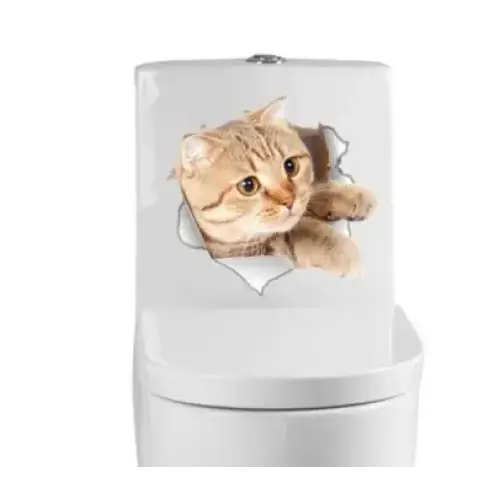A realistic orange tabby cat decal with detailed fur and wide eyes, appearing to peek through a torn paper effect on the white toilet tank.