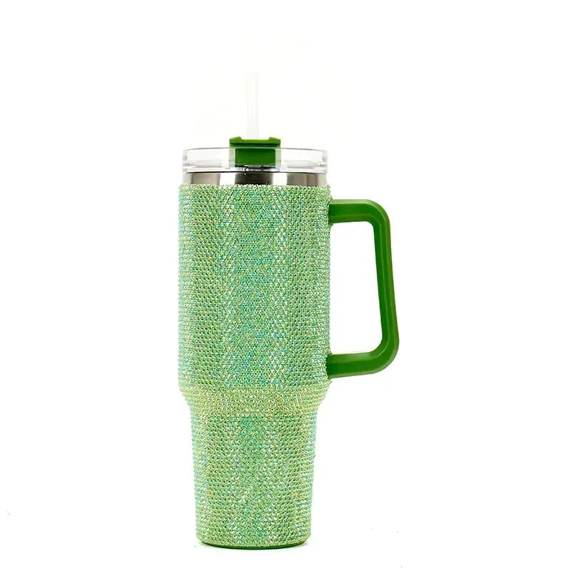 A sparkling green rhinestone-encrusted insulated tumbler with a matching handle and clear lid featuring a straw.