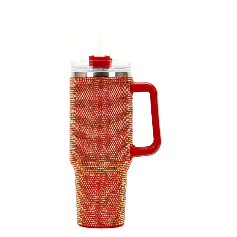 Red-handled insulated tumbler adorned with sparkling orange rhinestones and a clear lid featuring a red straw.