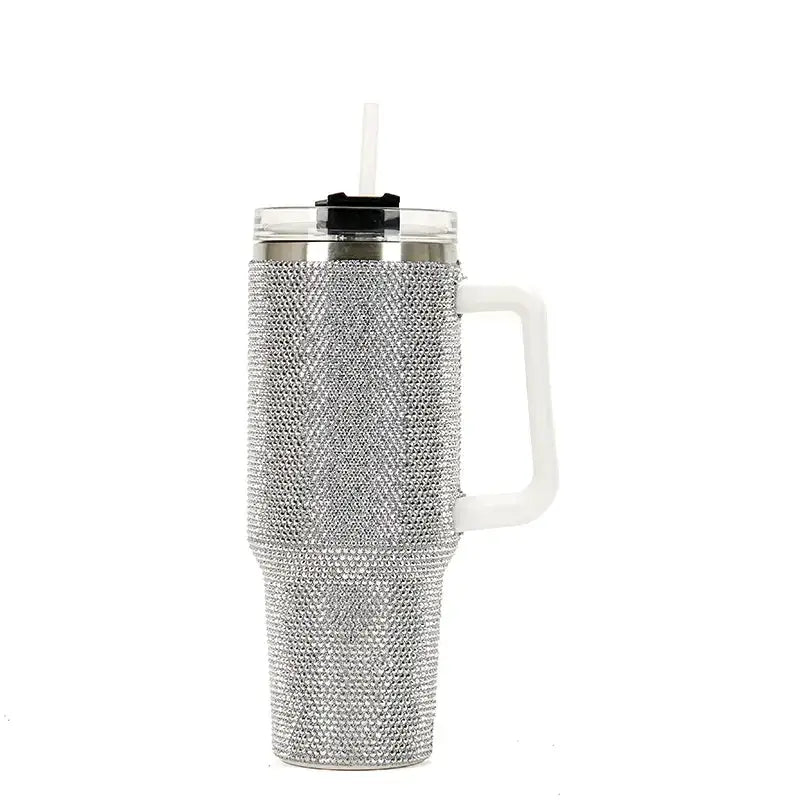 Silver rhinestone-encrusted insulated tumbler with a white handle and clear lid featuring a black straw.