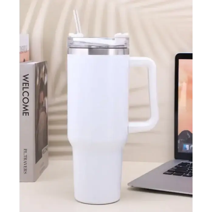 White insulated travel mug with a handle and clear lid featuring a straw.