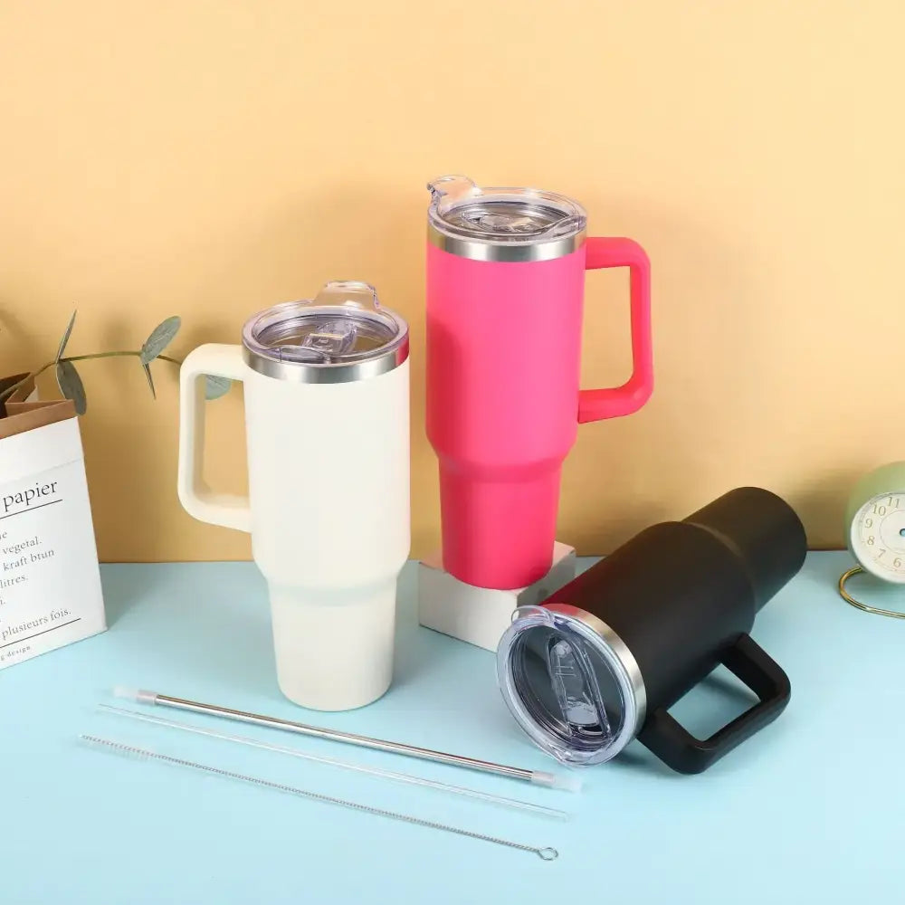 Pink insulated travel mug with a silver rim and handle.