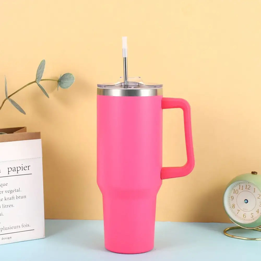 Pink insulated travel mug with a stainless steel lid and handle.