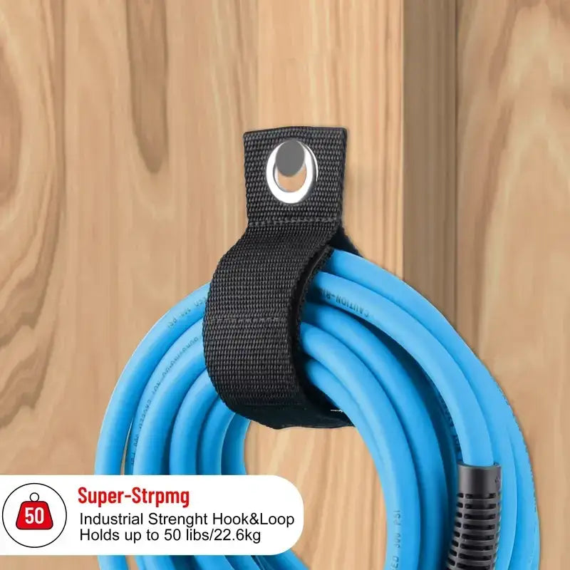 Black industrial-strength hook-and-loop hose organizer holding a coiled blue air compressor hose.