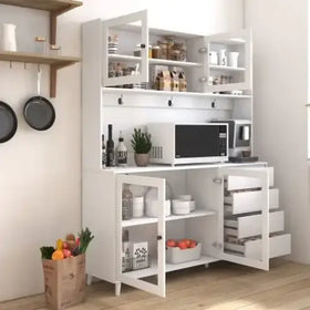 White kitchen cabinet with glass doors, open shelves displaying jars and mugs, microwave on top shelf, drawers below for storage