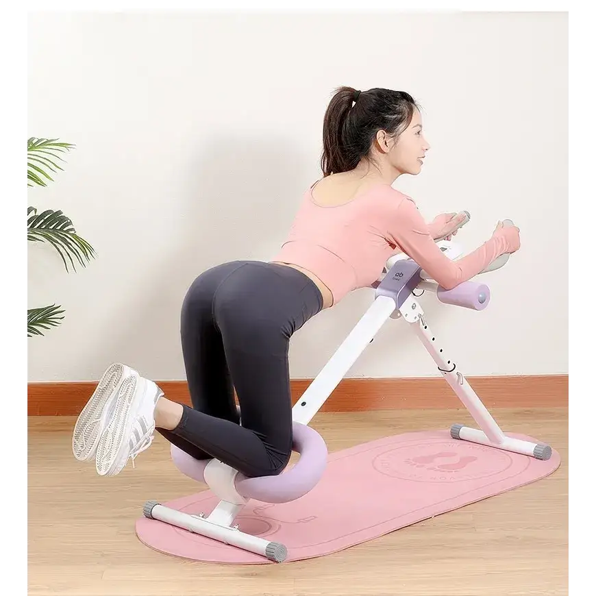 Pink and white abdominal exercise machine with padded handles and a supportive seat.