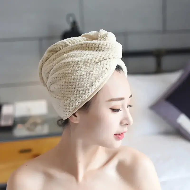 Beige textured microfiber towel wrapped around head in a neat, twisted knot.