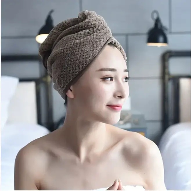 A soft, beige microfiber towel wrapped neatly around a woman’s head.