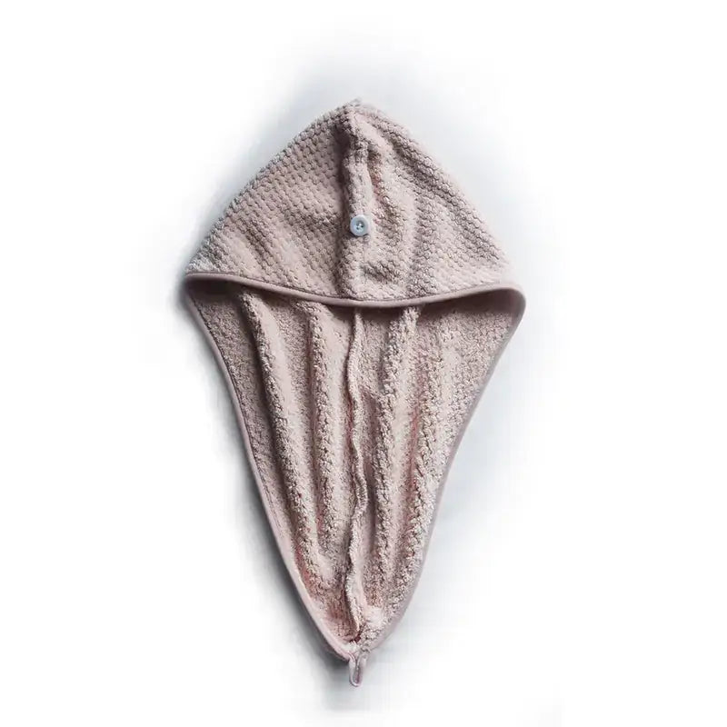 A soft, dusty rose-colored hooded towel with a textured terry cloth weave and a small button closure at the front.