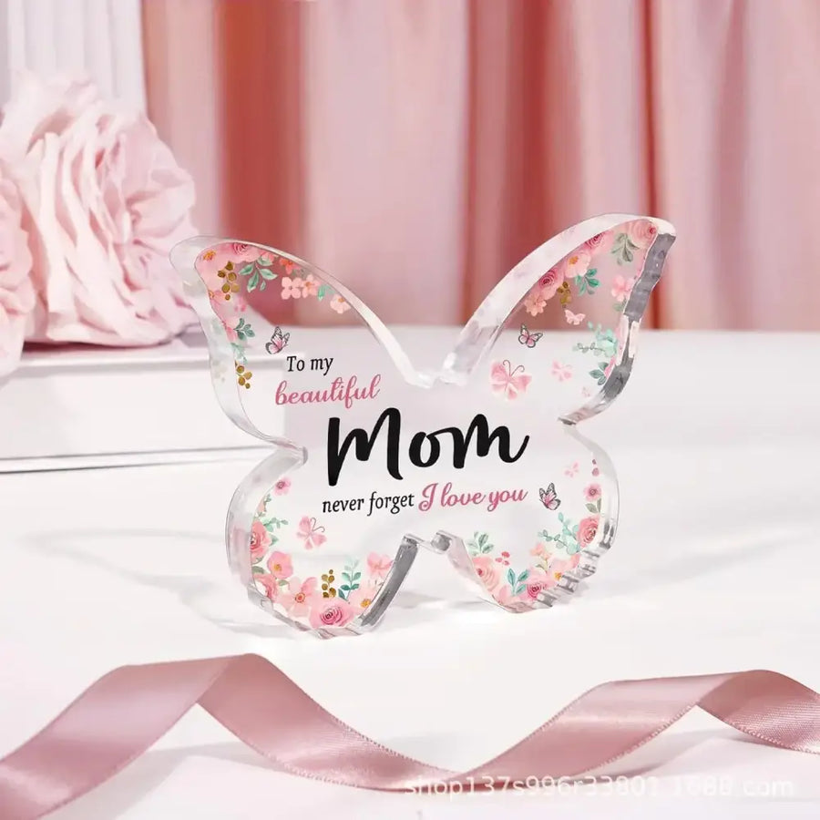 A clear acrylic butterfly-shaped keepsake with pink floral patterns and the inscription ’to my beautiful mom never forget i love you.’