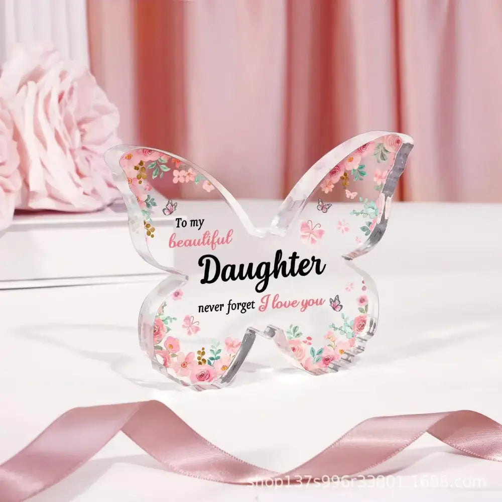 Clear acrylic butterfly-shaped keepsake with pink floral and butterfly decals, featuring the inscription ’to my beautiful daughter never forget i love you’ in black and pink script.