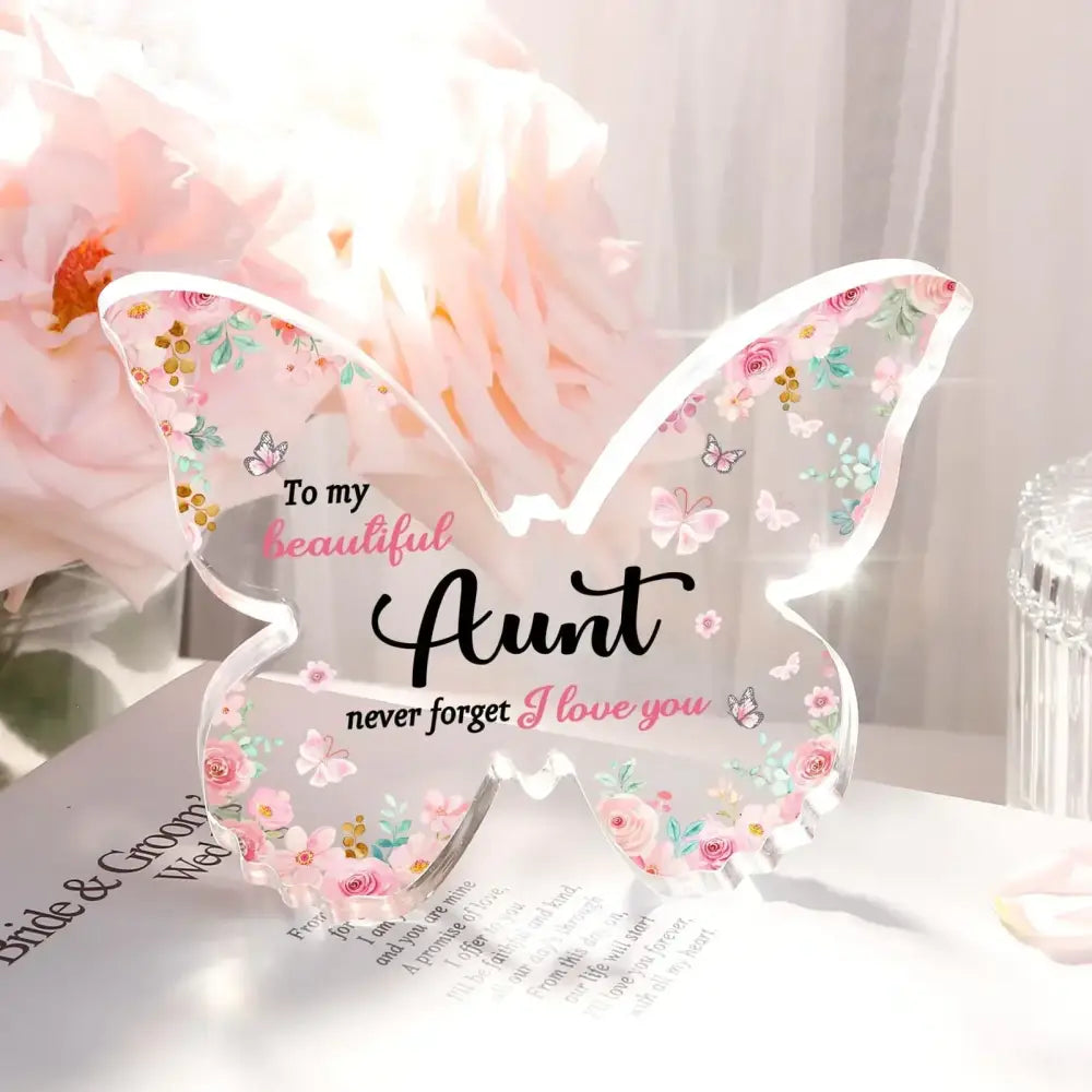 Clear acrylic butterfly-shaped keepsake with delicate pink and green floral patterns, small butterflies, and the inscription ’to my beautiful aunt never forget i love you’ in black cursive script.