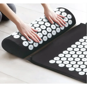 Black cylindrical and rectangular massage cushions with white circular acupuncture points.
